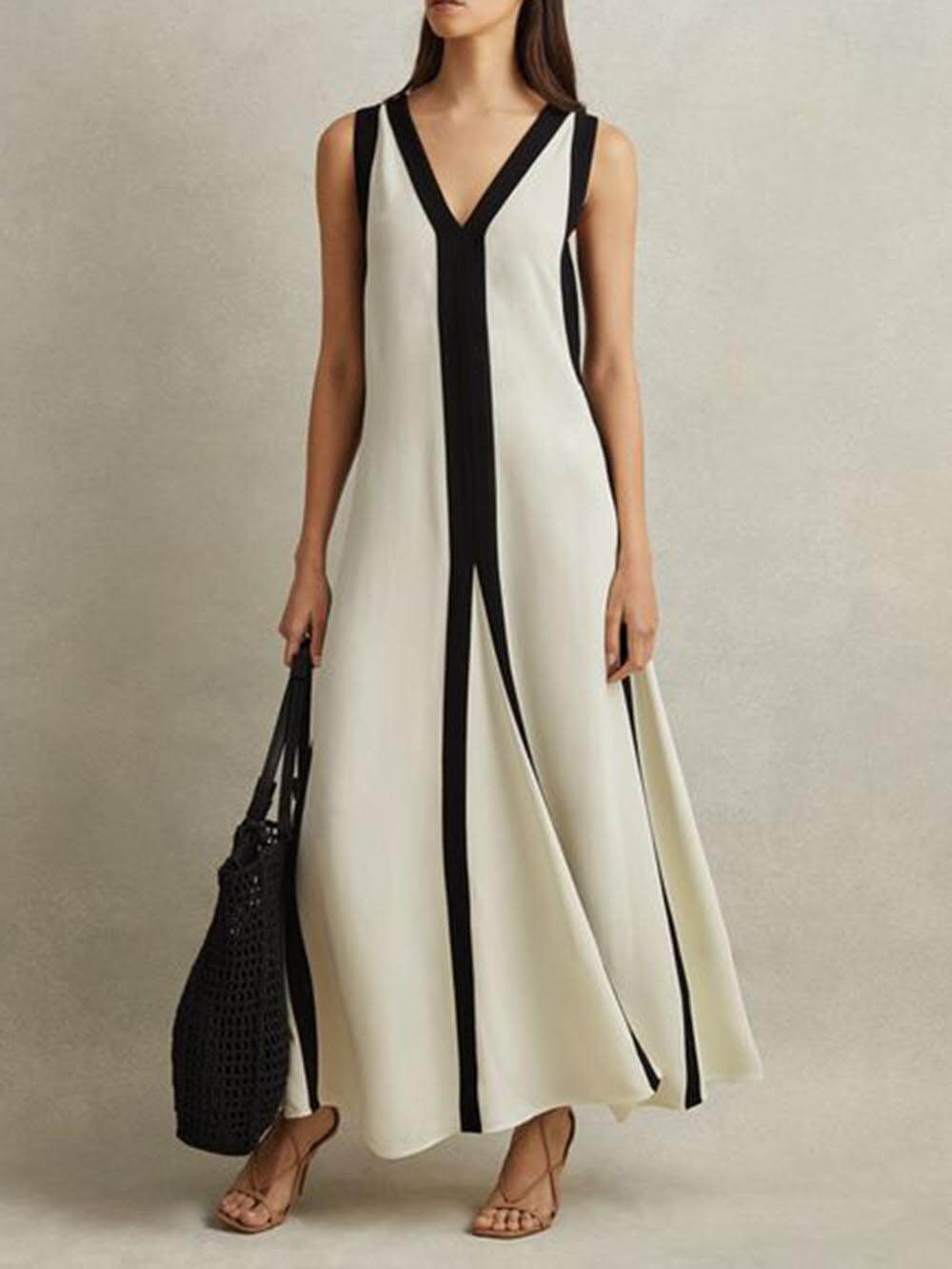 Contrasterende Zwart-Witte Maxi Jurk met Diepe V-Hals en Cut-Out Detail